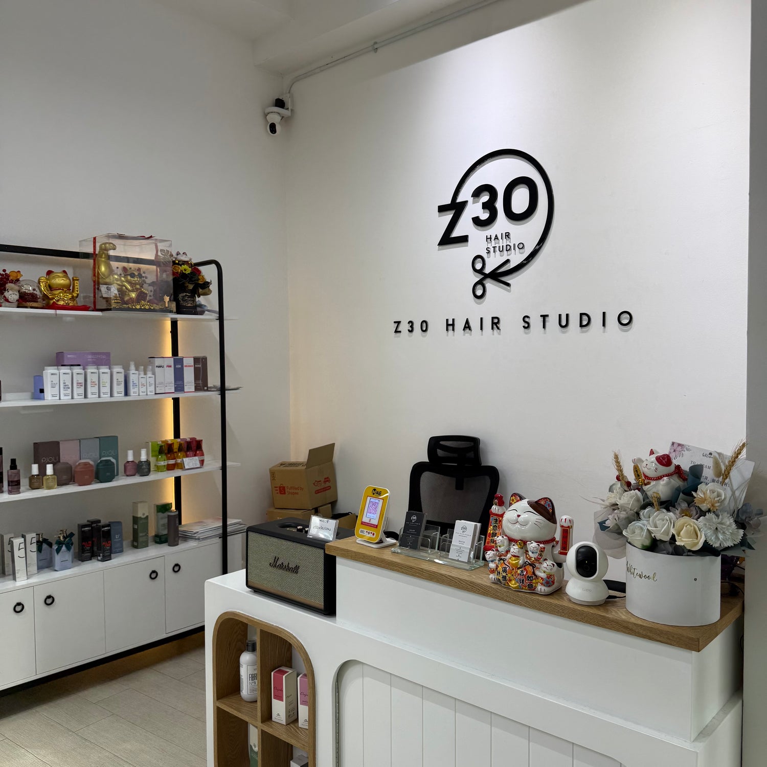 Z30 Hair Studio interior with branding on the wall and products on shelves.